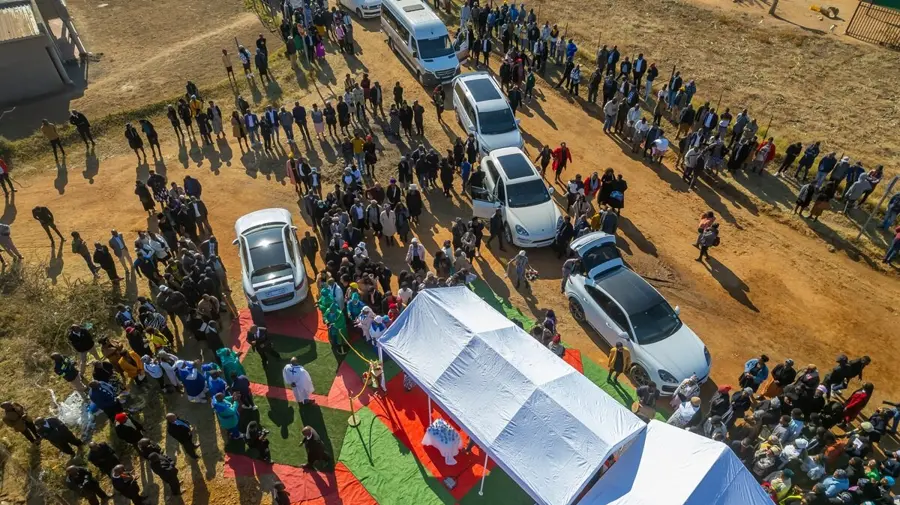 An aerial view of a large community gathering at a funeral service arranged by Mashigo